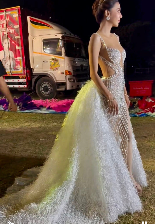 An elegant gown embellished with crystals for special occasions, featuring a long fur extension at the back.