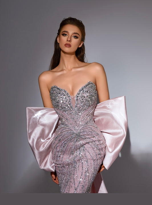 Elegant dress adorned with beads and sparkling crystals, featuring an organza piece with a bow at the back.”