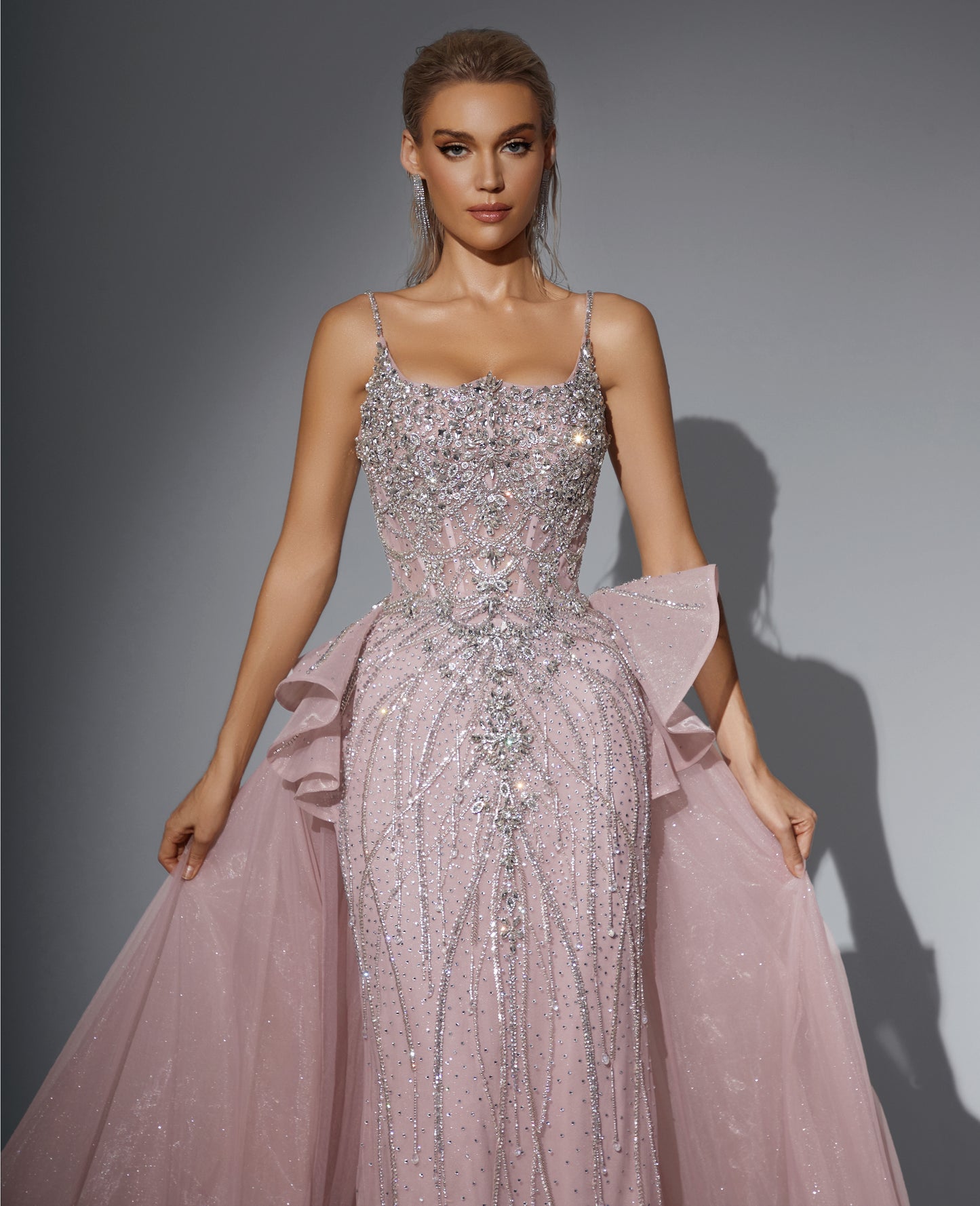 Luxurious dress adorned with gemstones, featuring a long train at the back.”