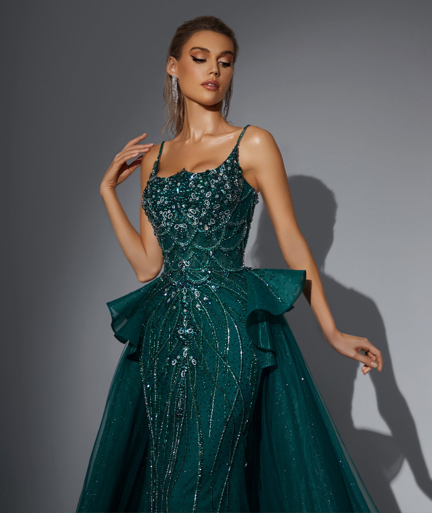 Luxurious dress adorned with gemstones, featuring a long train at the back.”