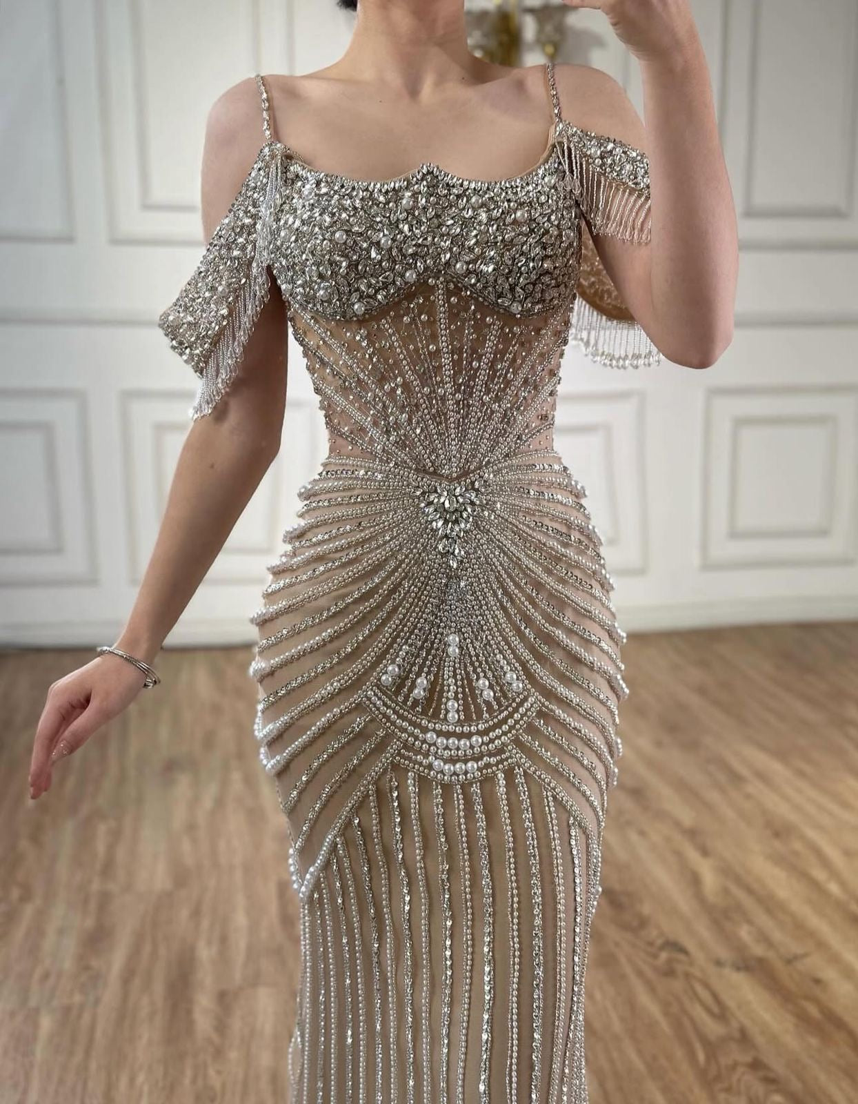 An elegant party dress with dazzling, stone-embellished off-shoulder sleeves.