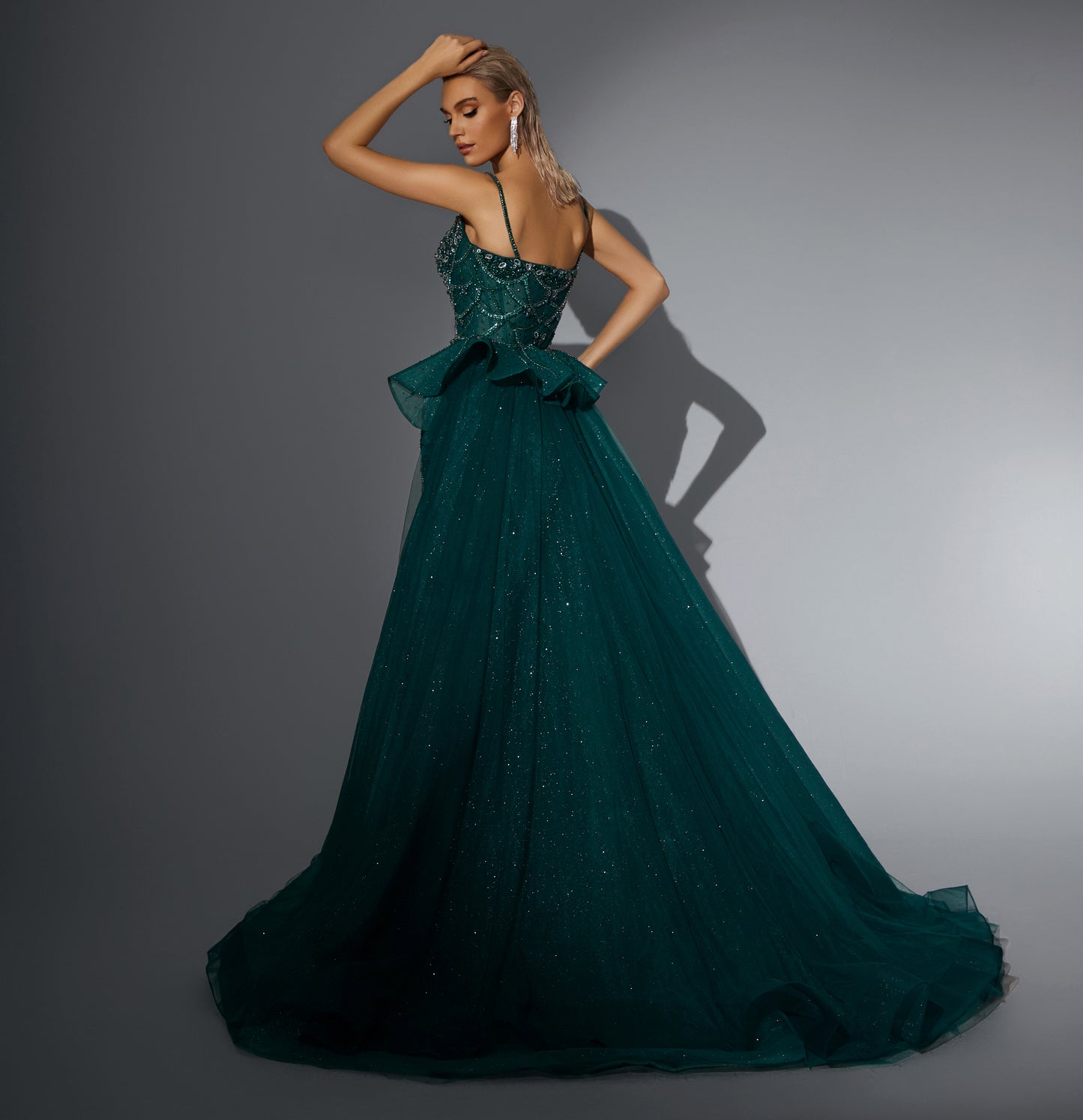 Luxurious dress adorned with gemstones, featuring a long train at the back.”