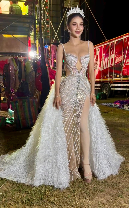 An elegant gown embellished with crystals for special occasions, featuring a long fur extension at the back.