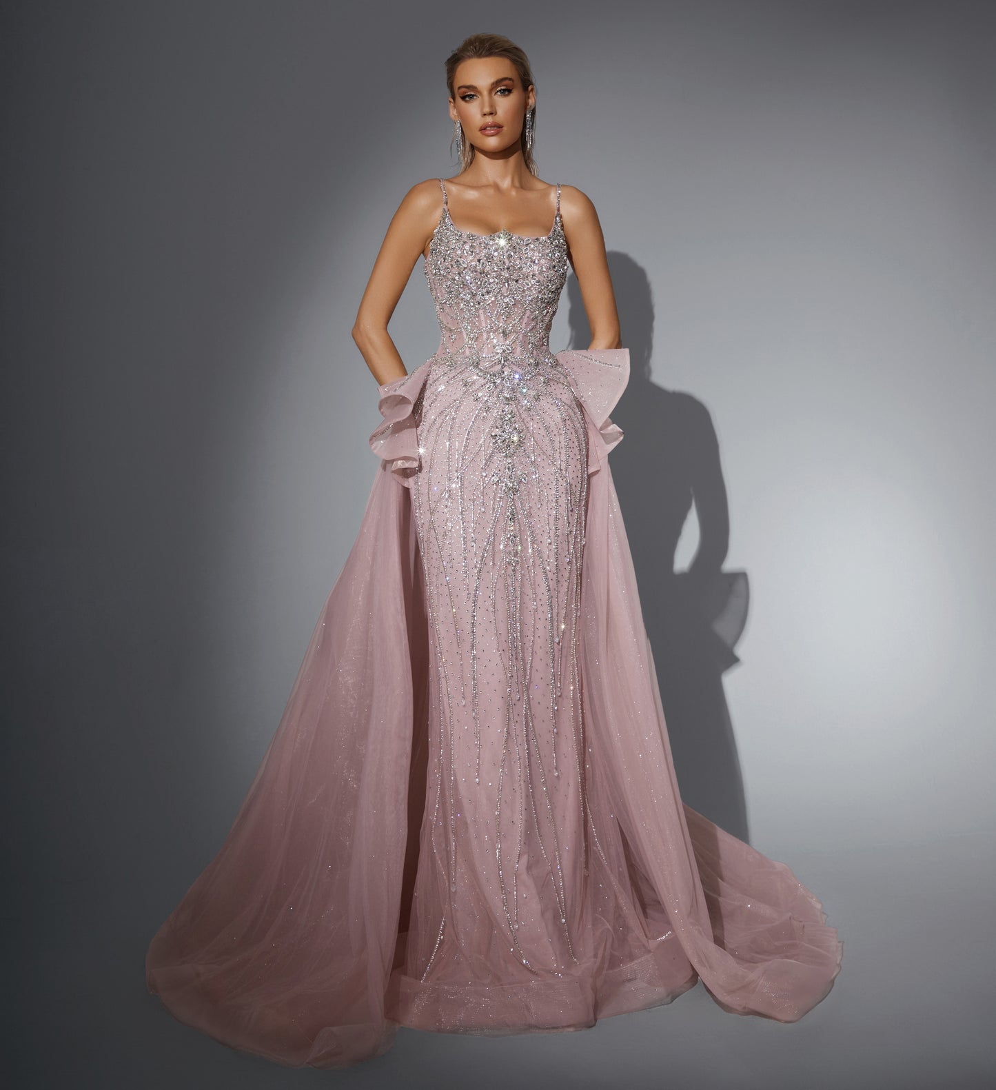 Luxurious dress adorned with gemstones, featuring a long train at the back.”
