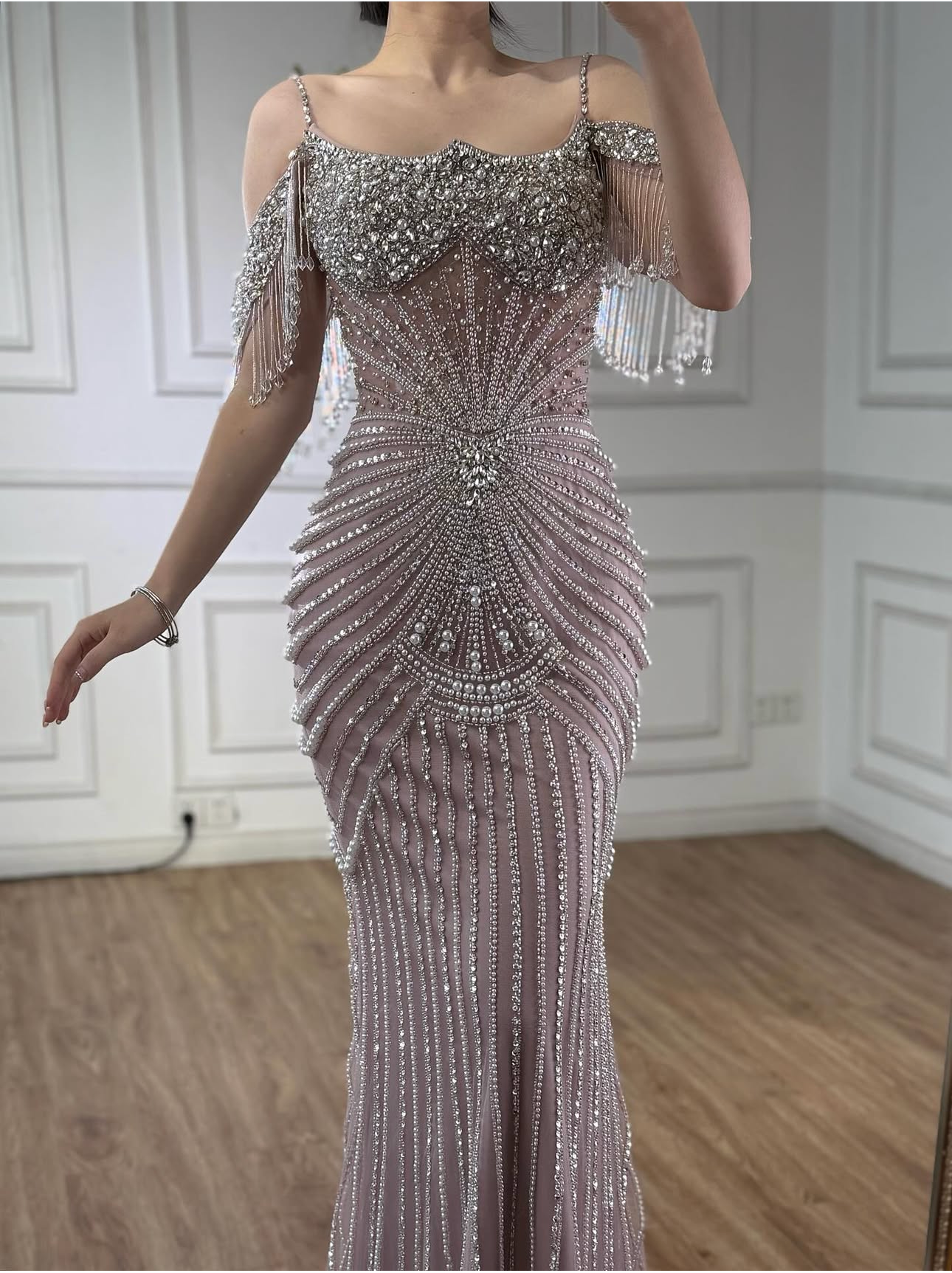 An elegant party dress with dazzling, stone-embellished off-shoulder sleeves.