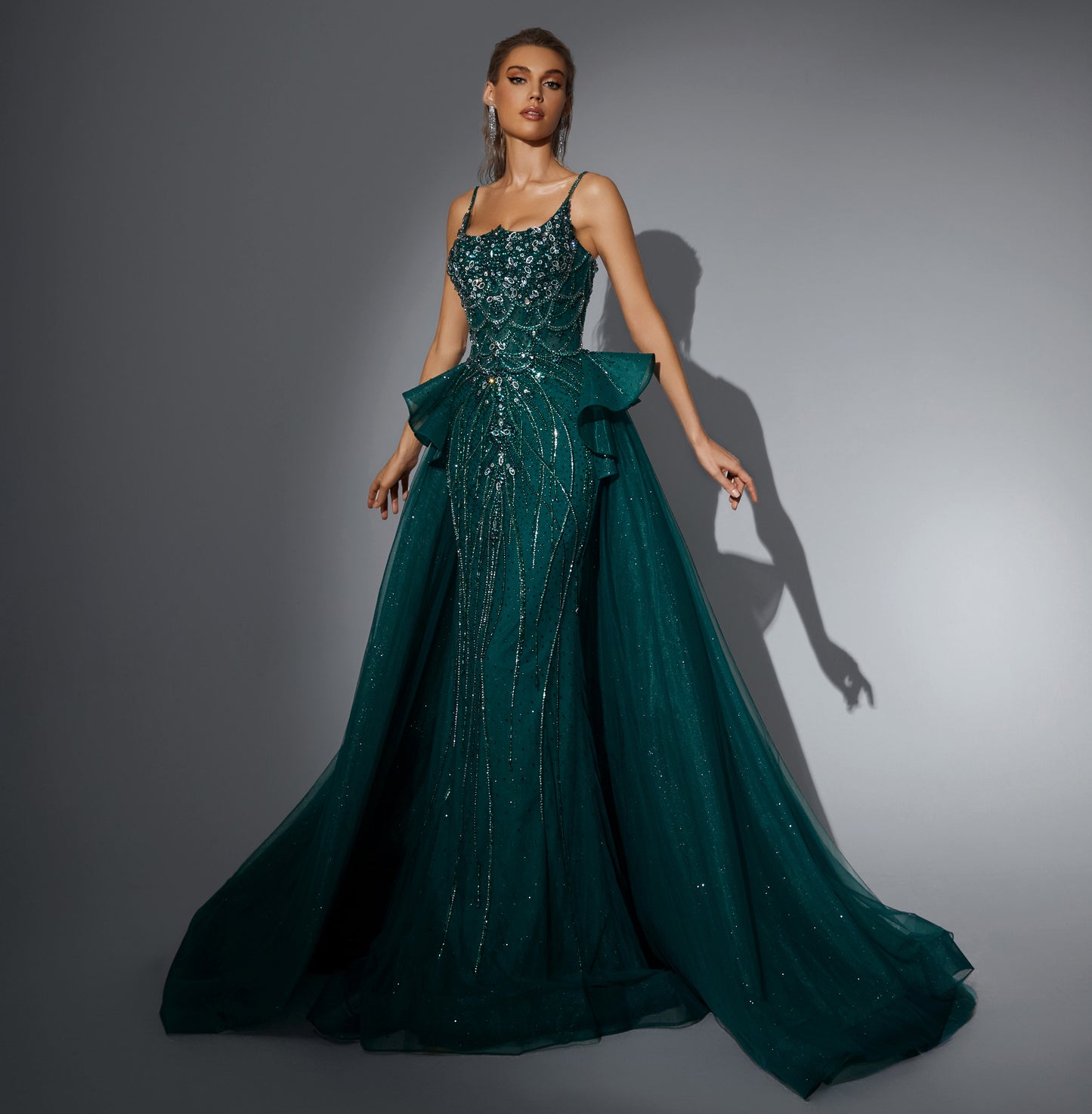 Luxurious dress adorned with gemstones, featuring a long train at the back.”